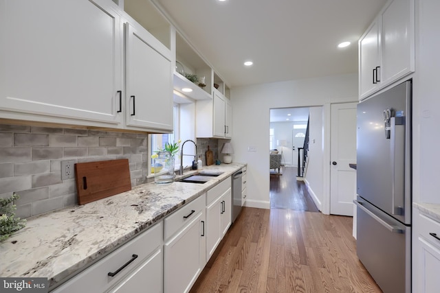 30 N Marshall St, Lancaster, PA 17602 - kitchen with a sink, tasteful backsplash, appliances with stainless steel finishes, light wood-style flooring, and white cabinets