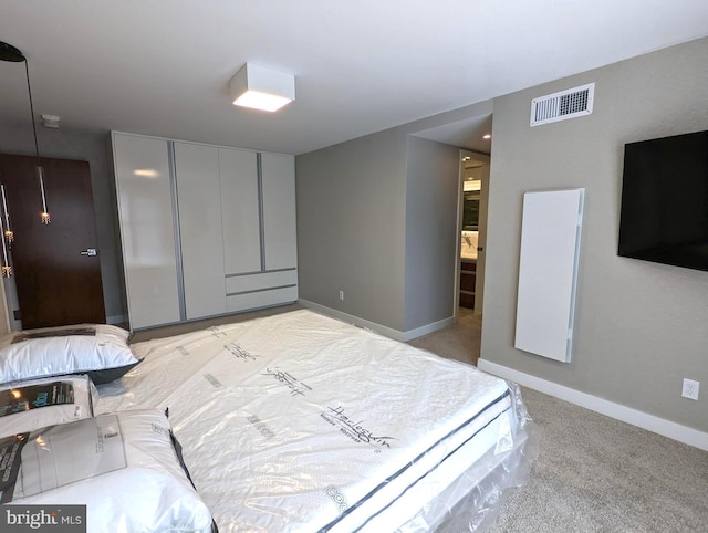 bedroom featuring baseboards, visible vents, a closet, and light colored carpet