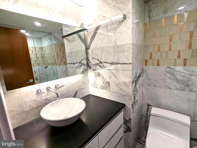 full bathroom featuring toilet, a shower with door, tile walls, and vanity