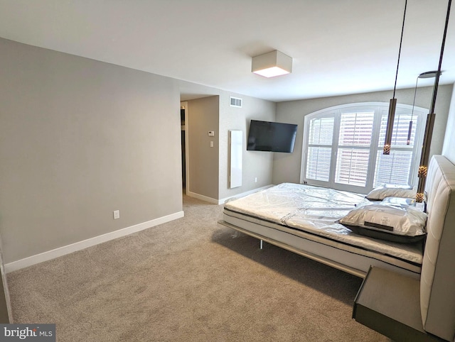 unfurnished bedroom featuring baseboards, visible vents, and light colored carpet