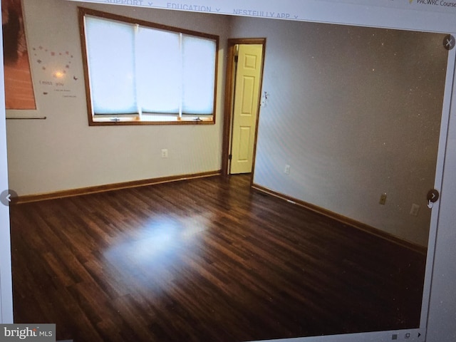 empty room featuring baseboards and wood finished floors