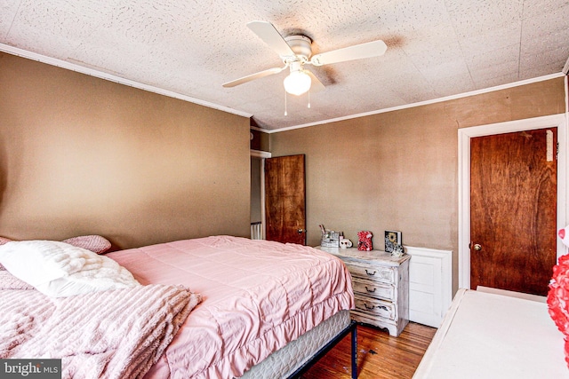 bedroom featuring a ceiling fan, crown molding, and wood finished floors