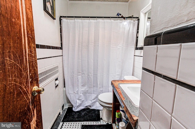 bathroom with toilet, vanity, tile walls, and a shower with curtain