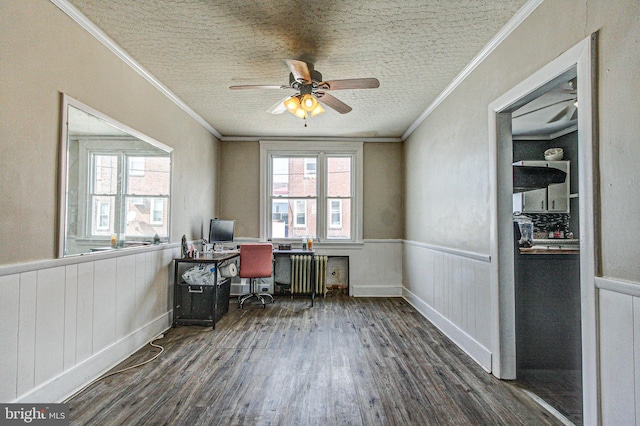 unfurnished office with crown molding, radiator heating unit, wainscoting, a textured ceiling, and wood finished floors