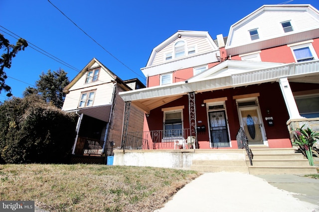 view of front facade with a porch and a gambrel roof