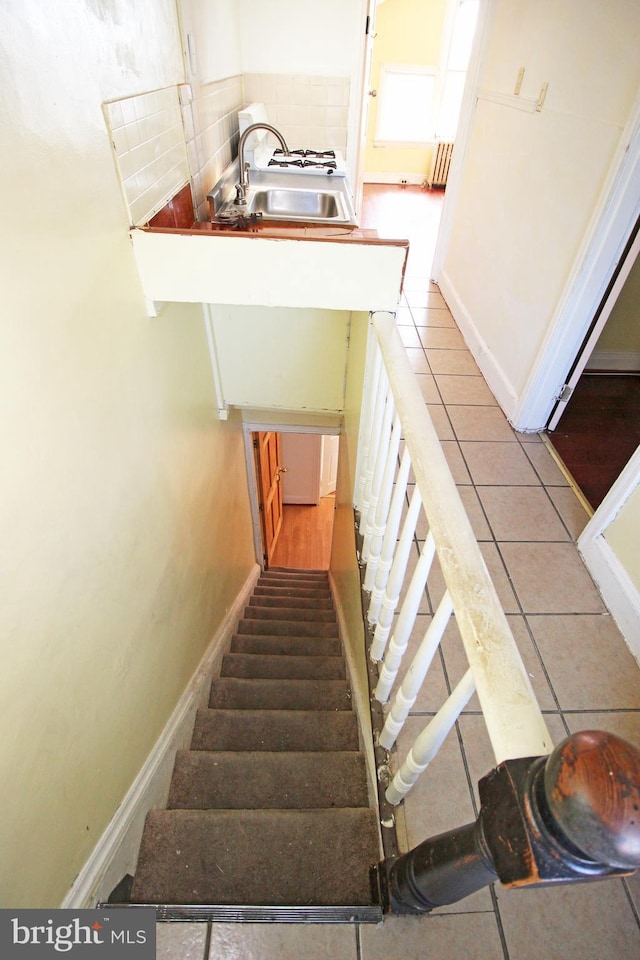 stairs with baseboards and tile patterned floors