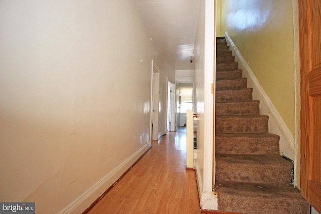 stairway with baseboards and wood finished floors