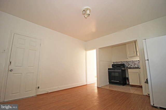 unfurnished living room featuring light wood-style floors and baseboards