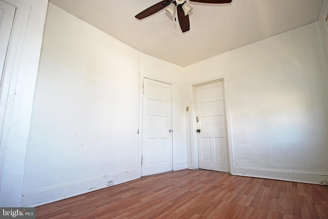 empty room with ceiling fan, baseboards, and wood finished floors