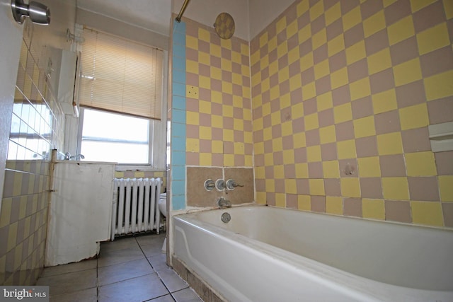 bathroom featuring radiator heating unit, a garden tub, toilet, and tile patterned floors