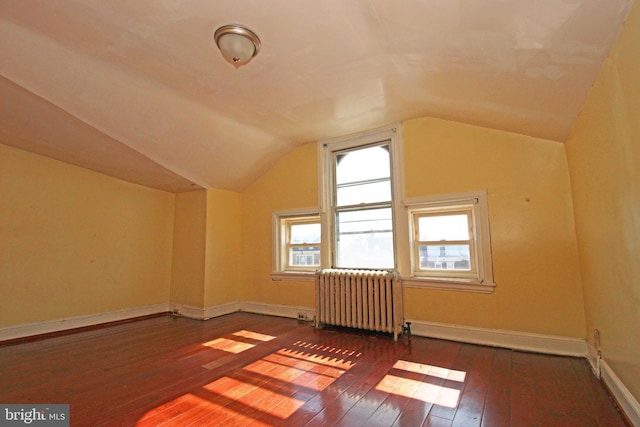 additional living space featuring radiator heating unit, vaulted ceiling, baseboards, and wood-type flooring