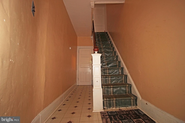 stairs with tile patterned flooring and baseboards