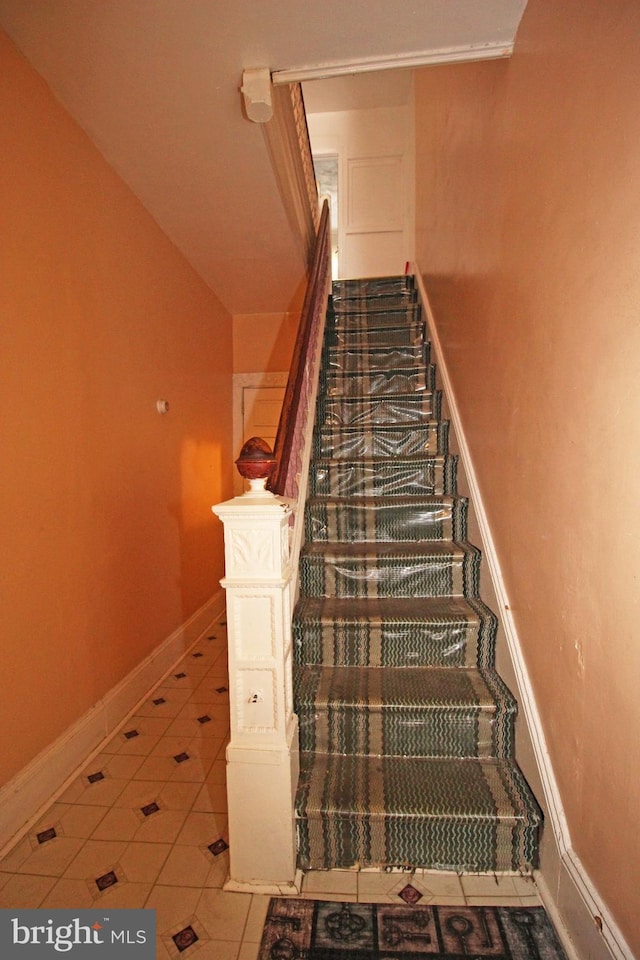 stairway with tile patterned flooring and baseboards