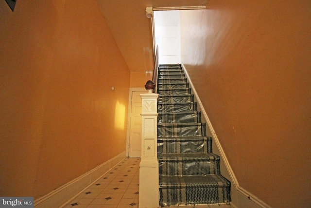 stairs featuring tile patterned flooring and baseboards