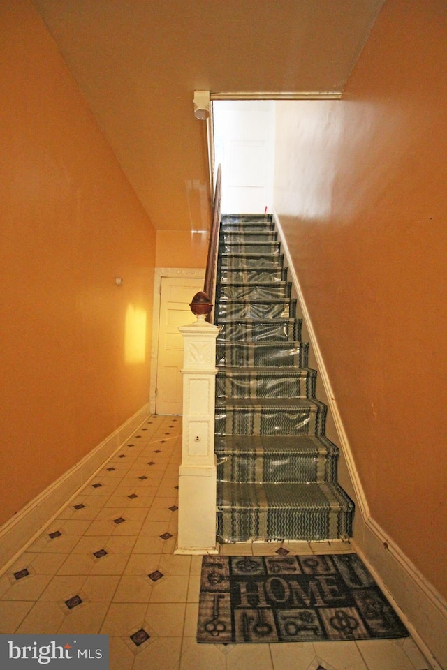 stairs featuring baseboards and tile patterned floors