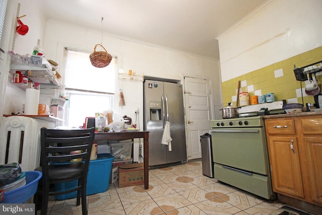 kitchen featuring electric range oven, crown molding, stainless steel fridge, and decorative backsplash