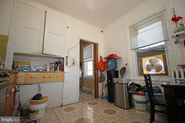 kitchen with crown molding, white cabinets, backsplash, and light tile patterned flooring