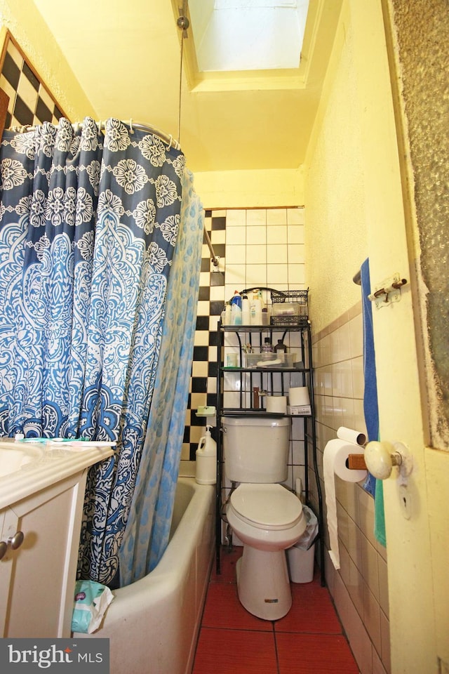 full bath featuring toilet, tile patterned floors, shower / bath combination with curtain, vanity, and tile walls