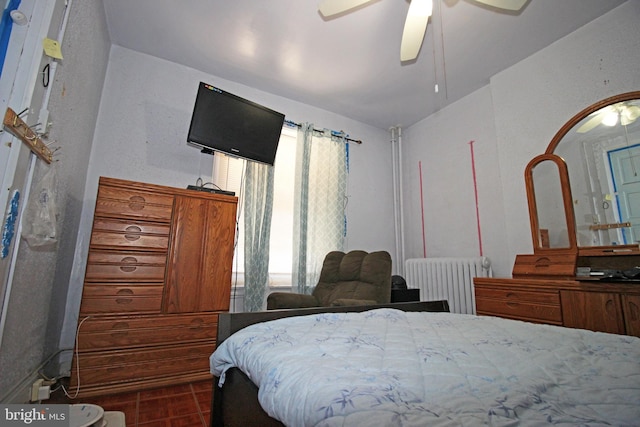 bedroom with a ceiling fan and radiator heating unit