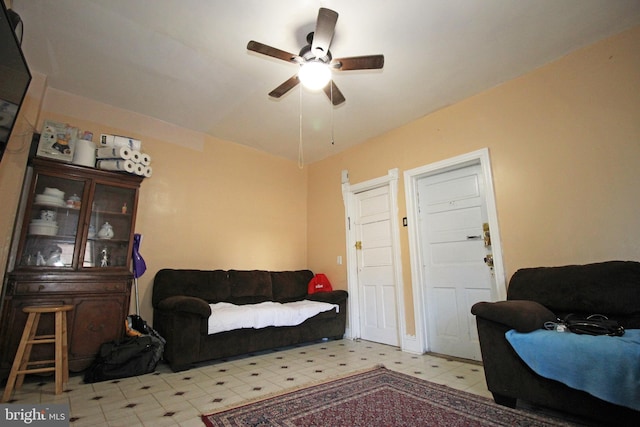 living area with ceiling fan and tile patterned floors