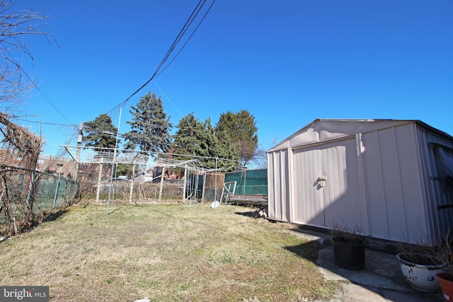 view of yard with a shed, an outdoor structure, and fence