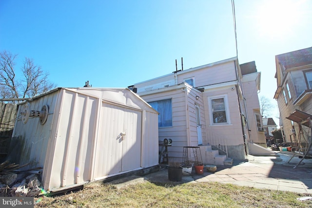 rear view of house with a storage shed and an outbuilding