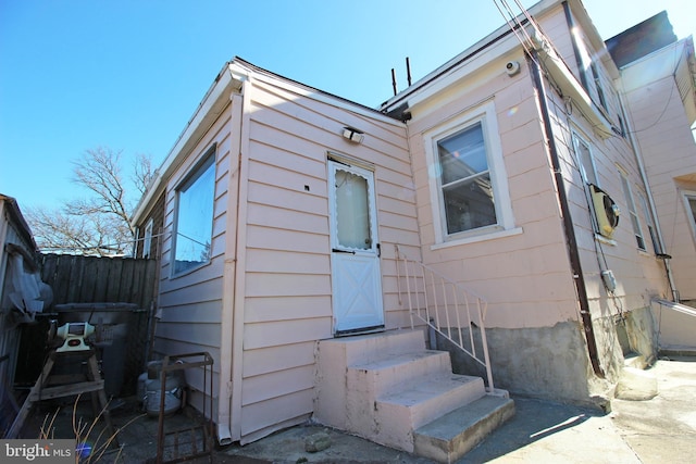 exterior space featuring entry steps and fence