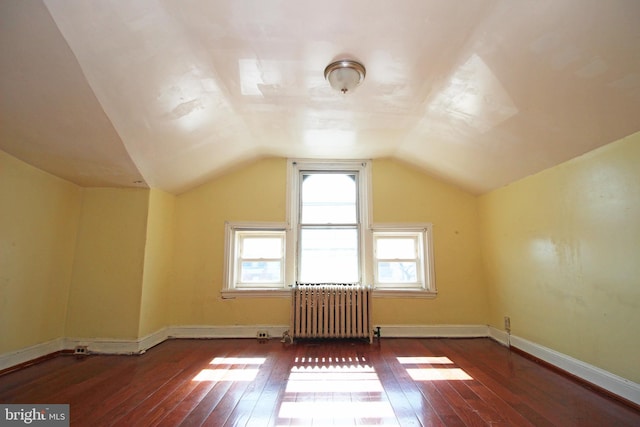 bonus room featuring baseboards, vaulted ceiling, hardwood / wood-style floors, and radiator heating unit