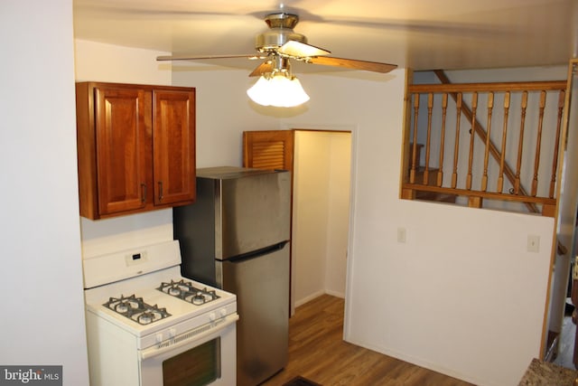 kitchen featuring ceiling fan, brown cabinets, wood finished floors, freestanding refrigerator, and gas range gas stove