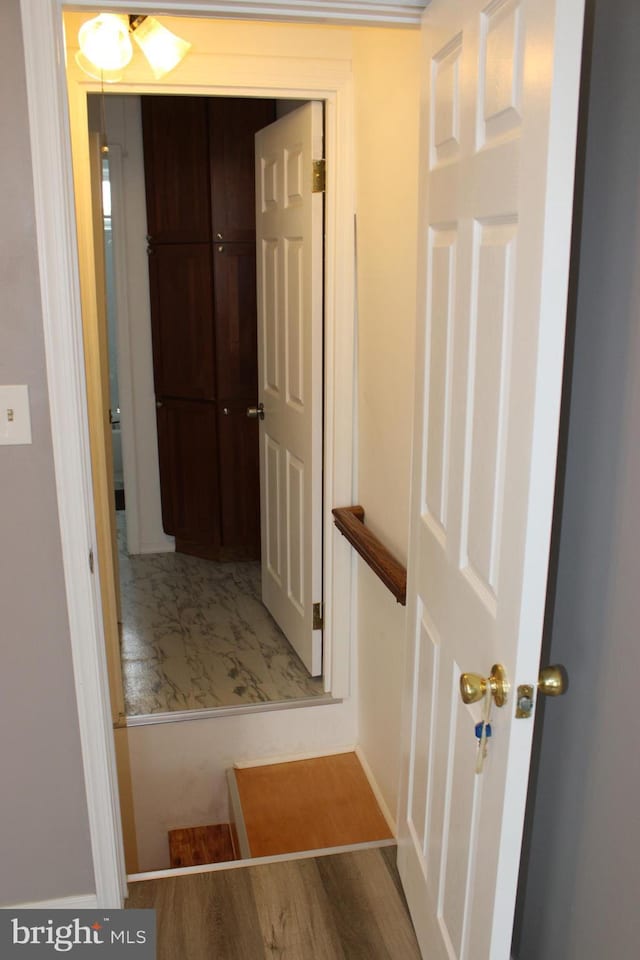 corridor with wood finished floors and baseboards