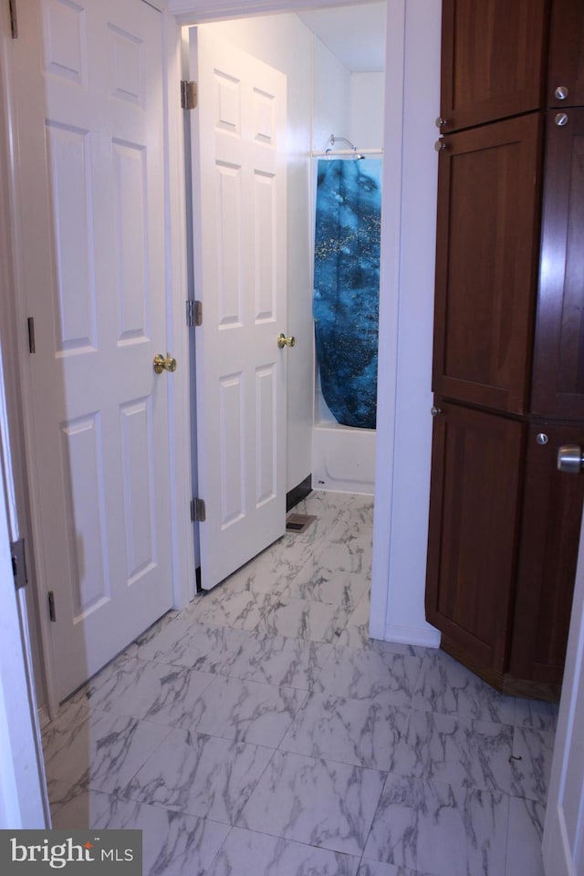 bathroom featuring marble finish floor and shower / bathing tub combination