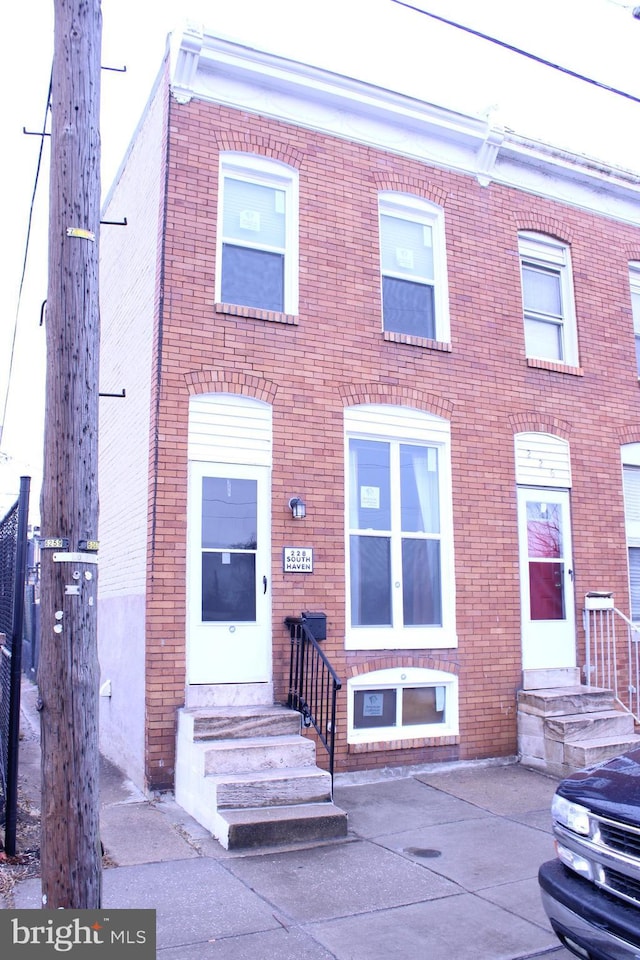 view of property featuring entry steps and brick siding