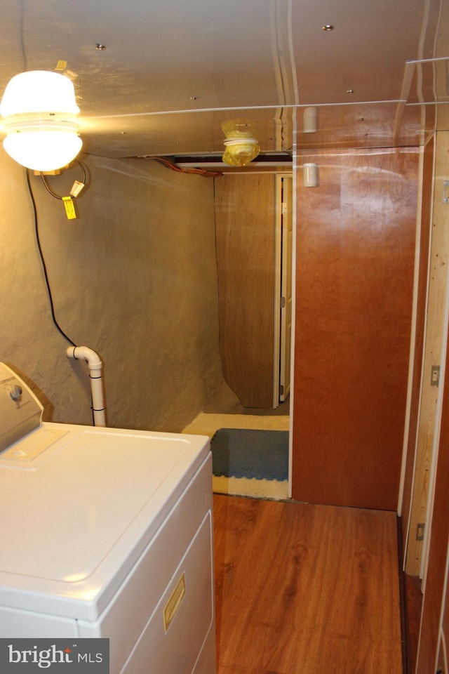 clothes washing area featuring laundry area, washer / clothes dryer, and wood finished floors