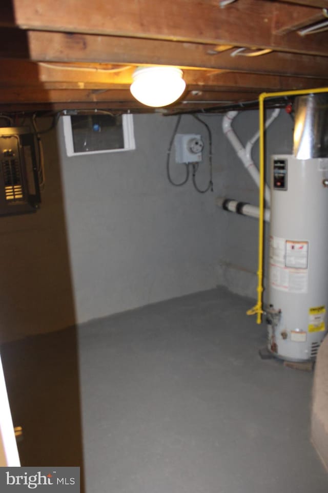 unfinished below grade area with electric panel and gas water heater