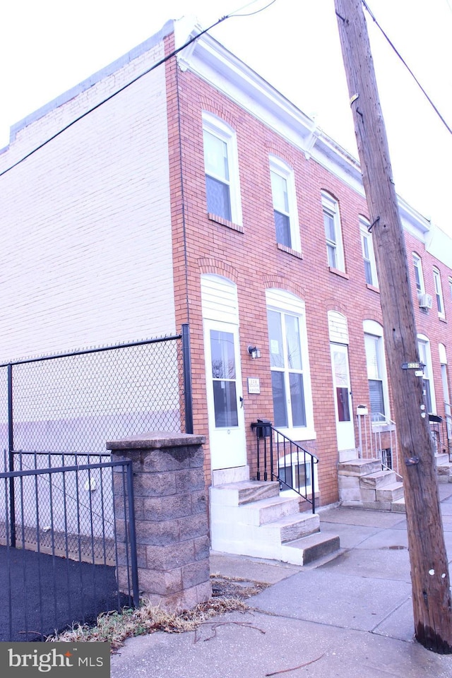 townhome / multi-family property featuring brick siding and fence