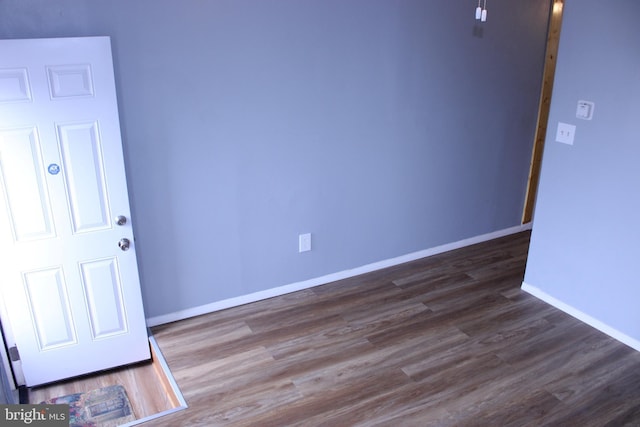 unfurnished room with baseboards and wood finished floors