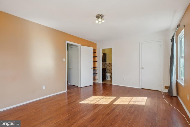 unfurnished bedroom featuring hardwood / wood-style flooring and baseboards