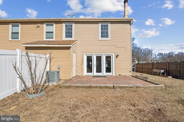 back of house featuring central AC, a patio, and a fenced backyard