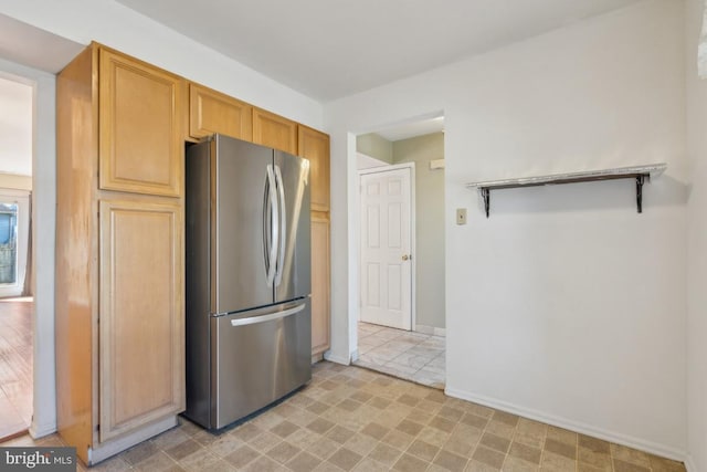 kitchen featuring freestanding refrigerator and baseboards