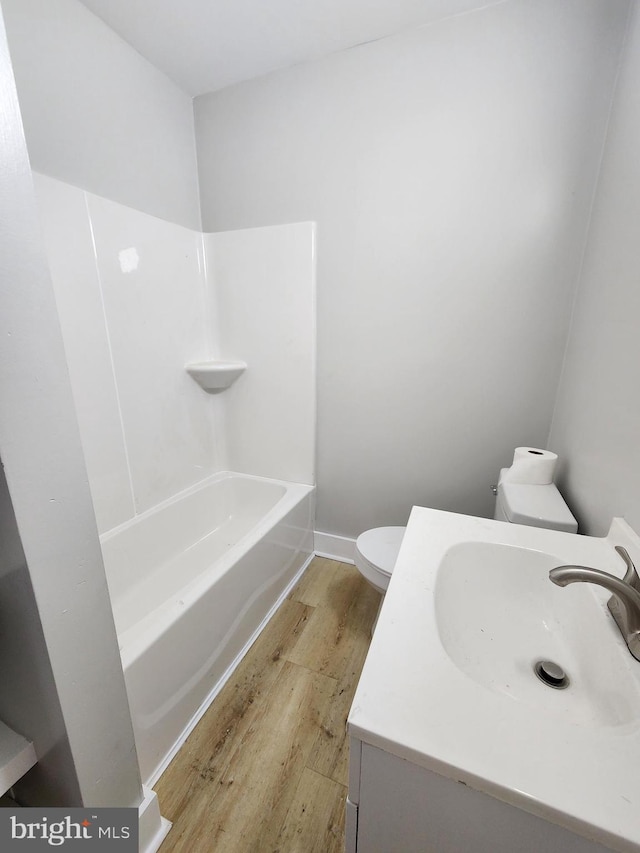 full bathroom with baseboards, vanity, toilet, and wood finished floors