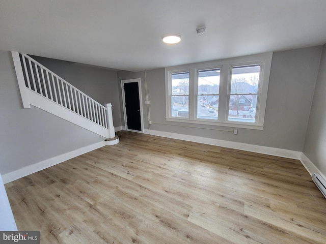 interior space with stairs, wood finished floors, and baseboards