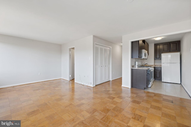 unfurnished living room featuring baseboards