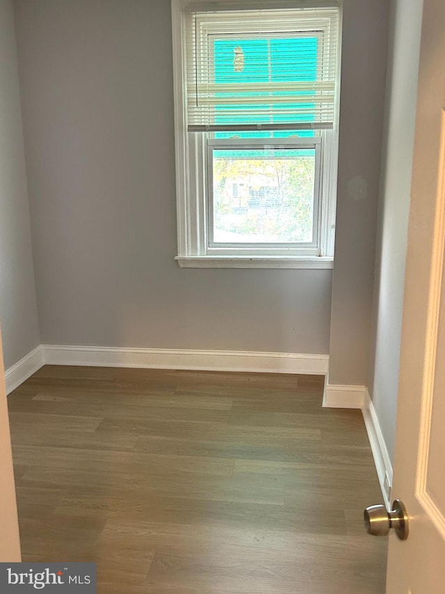 empty room featuring baseboards and wood finished floors