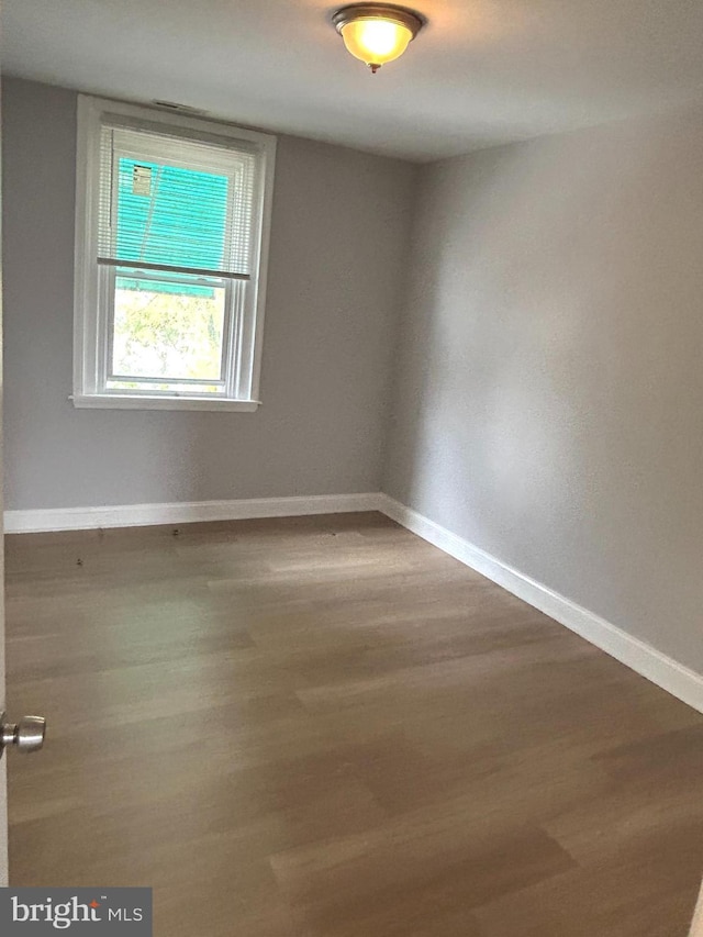 spare room with wood finished floors and baseboards