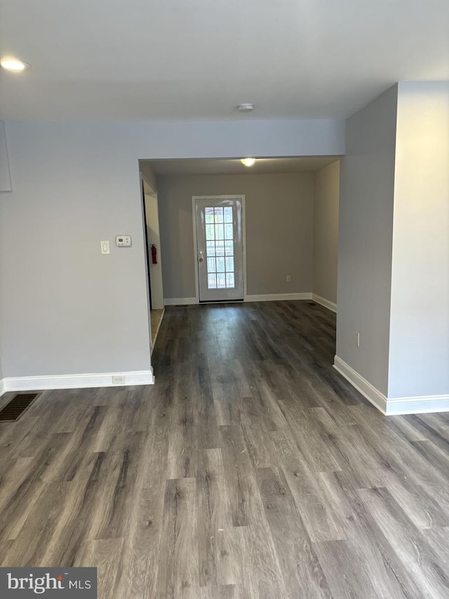 empty room featuring visible vents, baseboards, and wood finished floors