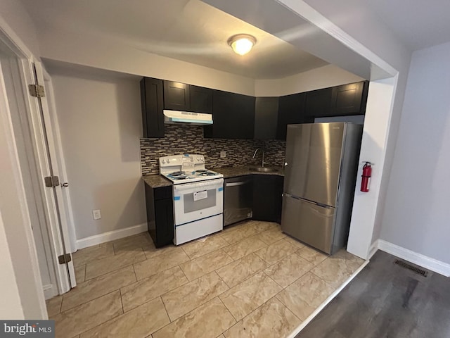 kitchen featuring visible vents, stainless steel appliances, dark cabinetry, under cabinet range hood, and backsplash