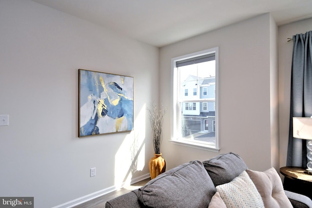 living area with baseboards and wood finished floors