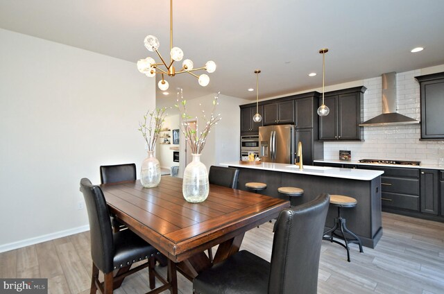 dining space featuring a chandelier, recessed lighting, light wood-style flooring, and baseboards