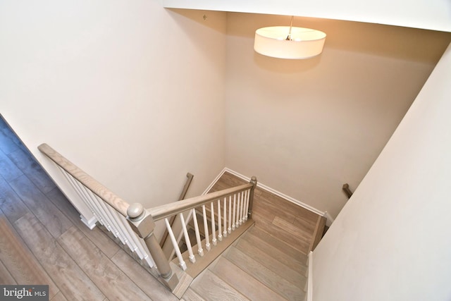 staircase with baseboards and wood finished floors