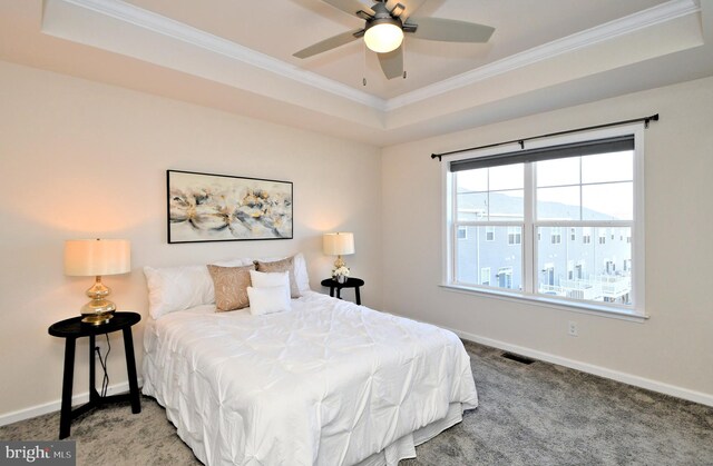 carpeted bedroom with a raised ceiling, crown molding, visible vents, and baseboards